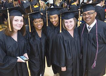 group of graduates smiling in cap and gown