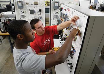 two students working on technical equipment