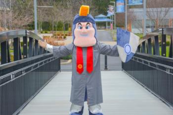 mascot standing on a bridge with arms wide open