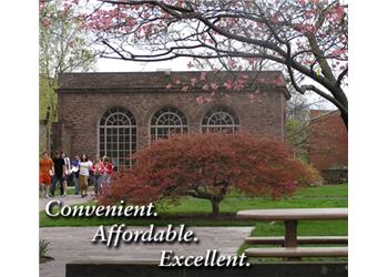 students outside red-brick building with 'convenient. affordable. excellent.'