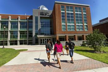 students walking near a modern campus building