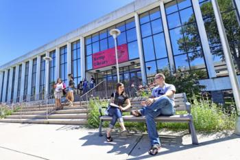 students sitting outside university library