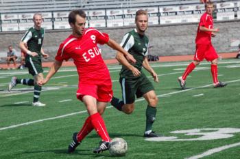 soccer player in red controlling ball during match