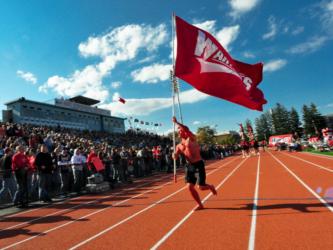 person running with a red flag on athletics track