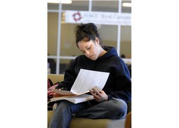 student reading in a campus lounge