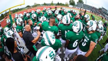 football team in huddle on the field