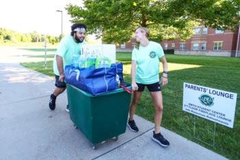 students moving belongings with cart