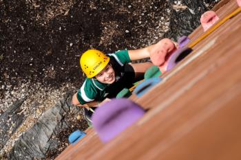 person rock climbing with a yellow helmet