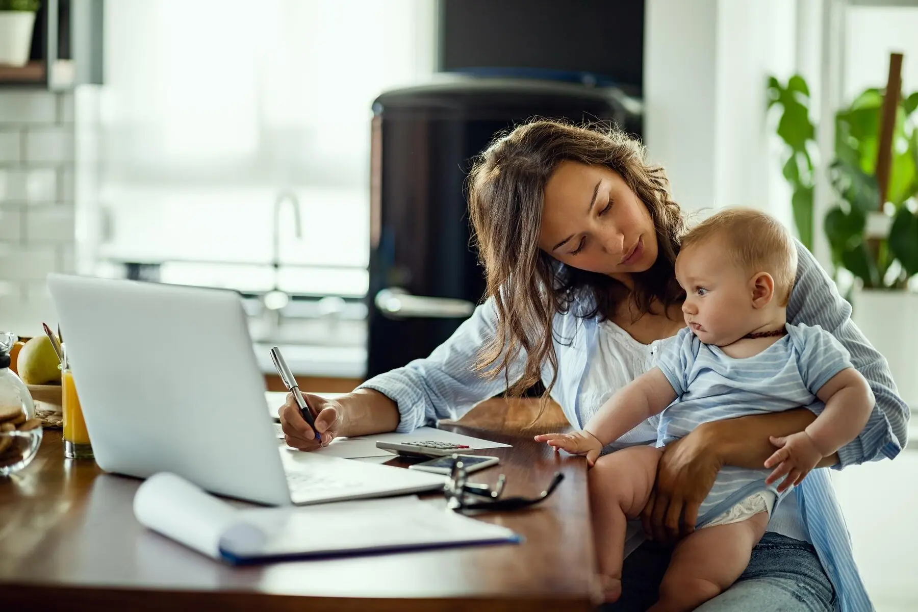 mom with baby doing work on laptop