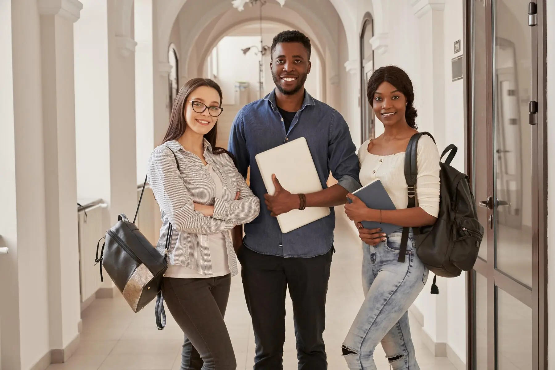 3 people standing in hallway smiling