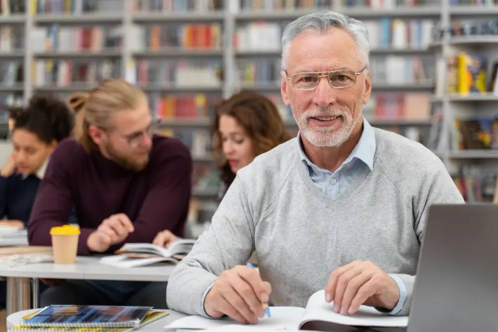 male smiling while working on laptop