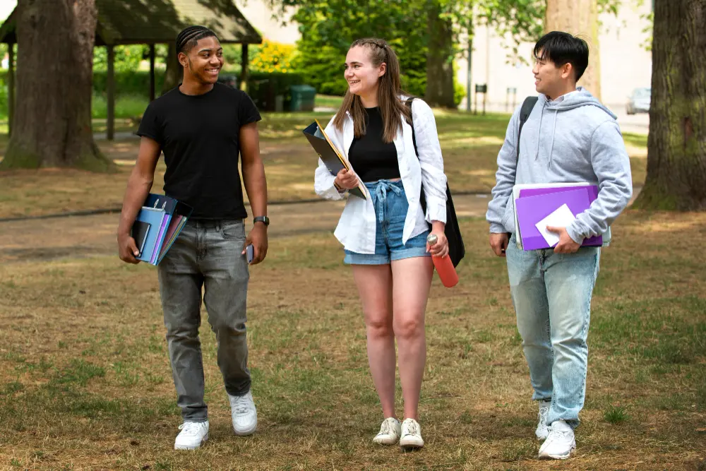 three high school students walking across a campus