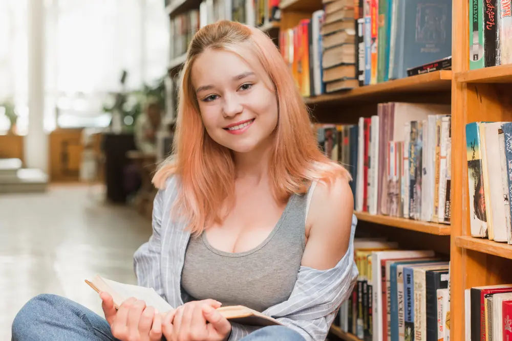 female student sitting in library smiling