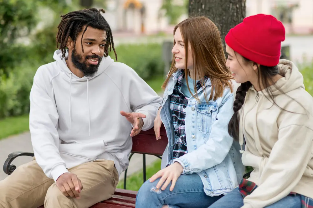 three students on bench talking